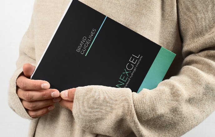 A printed brand guidelines book held in both hands